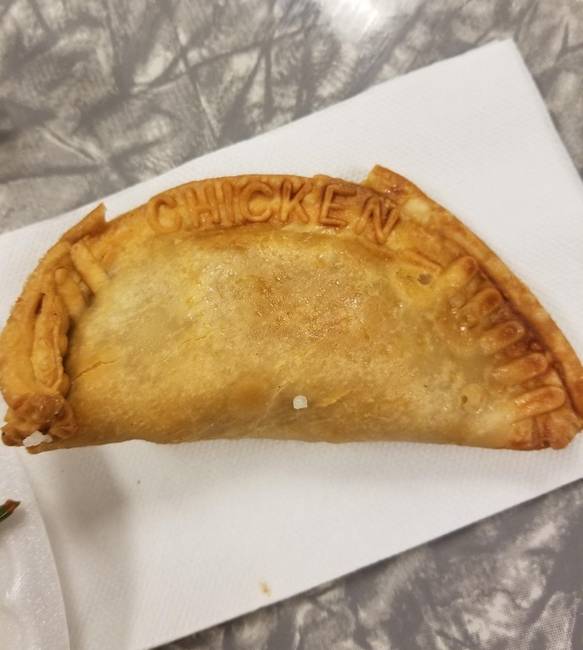 Egy étteremben felszolgált empanada, amibe belesütötték, hogy mivel van töltve a belseje.