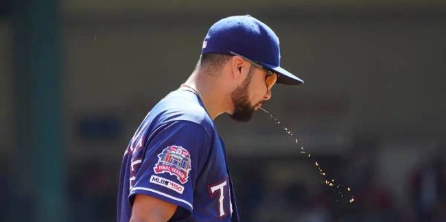 Egy baseballjátékos köpköd.