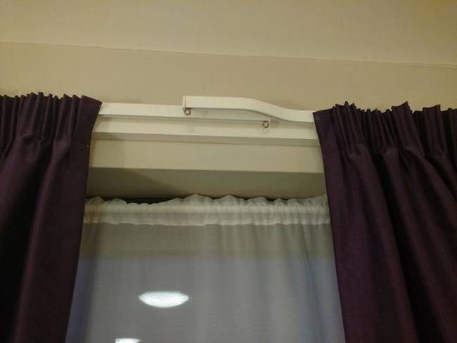 Egymást fedő függönykarnisok, amik gondoskodnak róla, hogy ne szűrődhessen be fény a függönyök között.