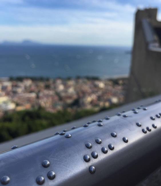 Ez a korlát Braille-írással segít leírni a vakok és gyengén látók számára Nápoly látképét.