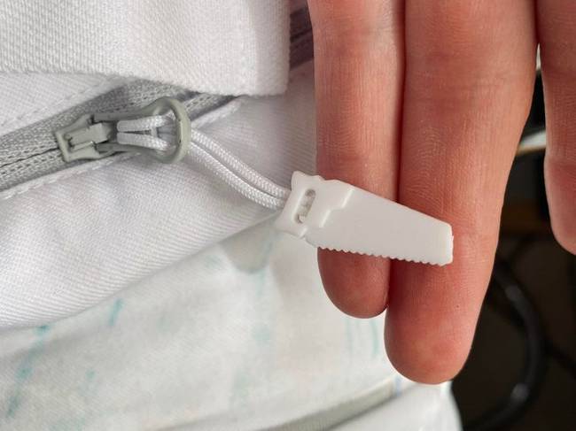 Ennek a munkásnadrágnak a cipzárján egy kis fűrész alakú vég található.