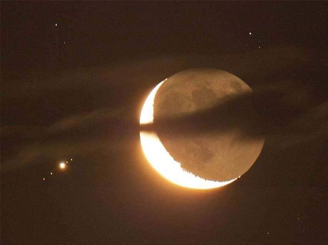 Növő Hold a Jupiterrel, és annak négy holdjával a háttérben.
