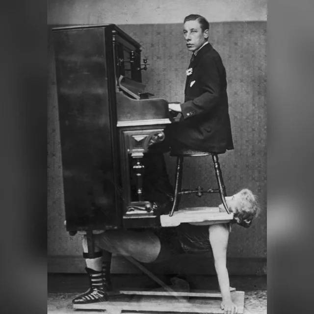 Egy erőművész nő, amint épp a mellén egyensúlyoz egy zongorát és egy zongoristát 1920-ban.