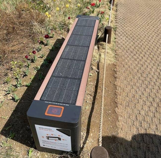 „Napenergiával működő pad Szöulban, Dél-Koreában. Vezeték nélküli töltő és USB dugó is található rajta."
