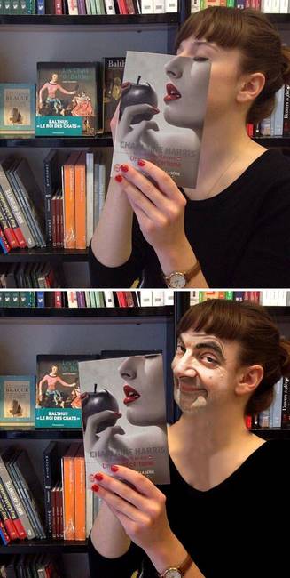 Az arca elé könyvet tartó nő.