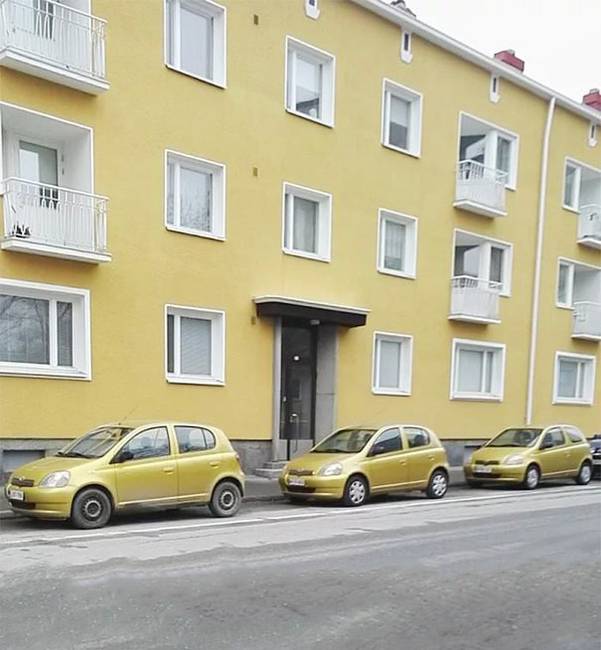 Három ugyanolyan színű és típusú autó egy ugyanolyan színű ház előtt.