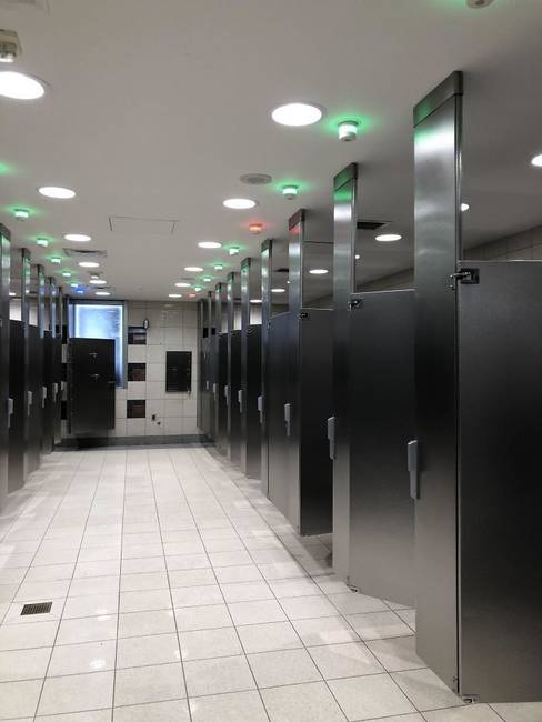 Egy nyilvános WC, ahol lámpák jelzik, hogy melyik fülke szabad és melyik nem.