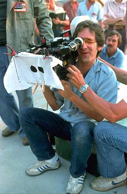 Steven Spielberg, amint épp az E. T., a földönkívüli című film azon jelenetéhez készült kamerát próbálgatja, amikor E.T. szellem ruhában mászkál az utcán a Halloweenező gyerekek között.