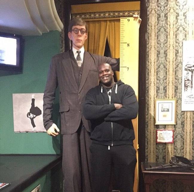 A kosárlabdázó Shaquille O’Neal (216 cm magas) a történelem legmagasabb emberének szobra mellett.