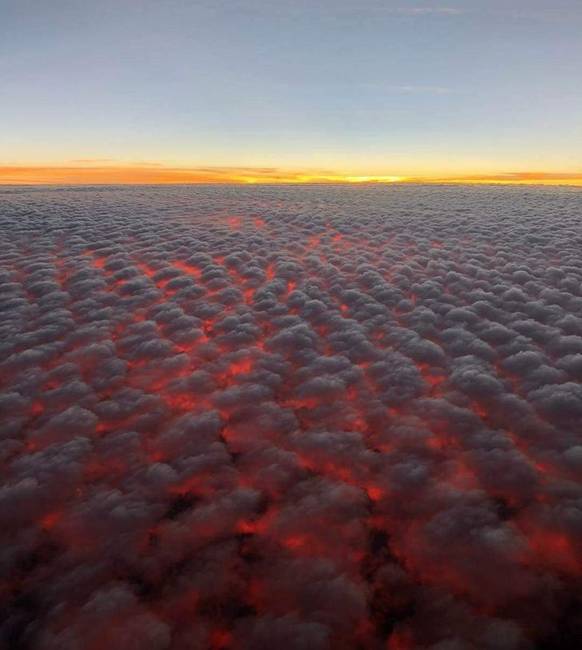 Az Altocumulus felhők olvadt lávának tűnnek a naplemente fényében, 9000 méter magasságban.