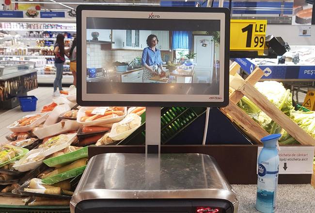 Ebben a romániai boltban még a digitális mérlegen is reklámokat kell nézniük a vásárlóknak. Ha meg akarod mérni valamelyik zöldségnek vagy gyümölcsnek a súlyát, előbb végig kell nézned egy reklámot.
