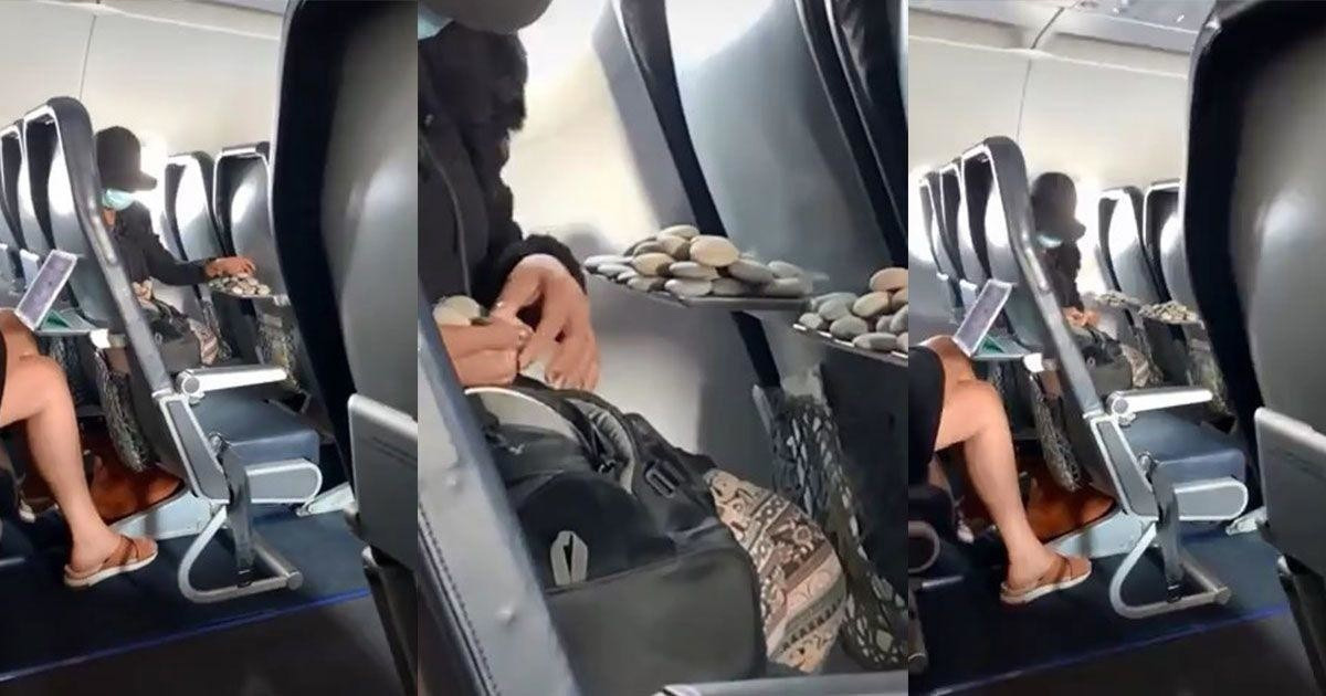 Kövekkel játszó nő a repülőn