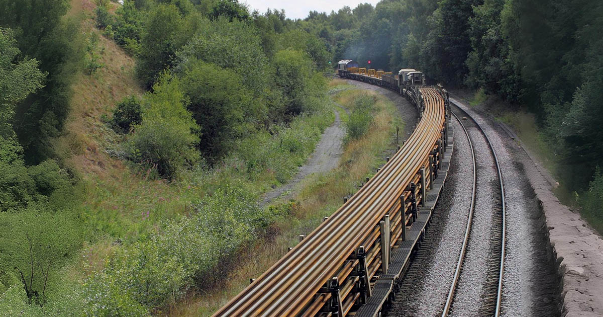 Hogyan kanyarodik egy vonat a 800 méteres sínek szállítása közben, és miért nem törnek el?